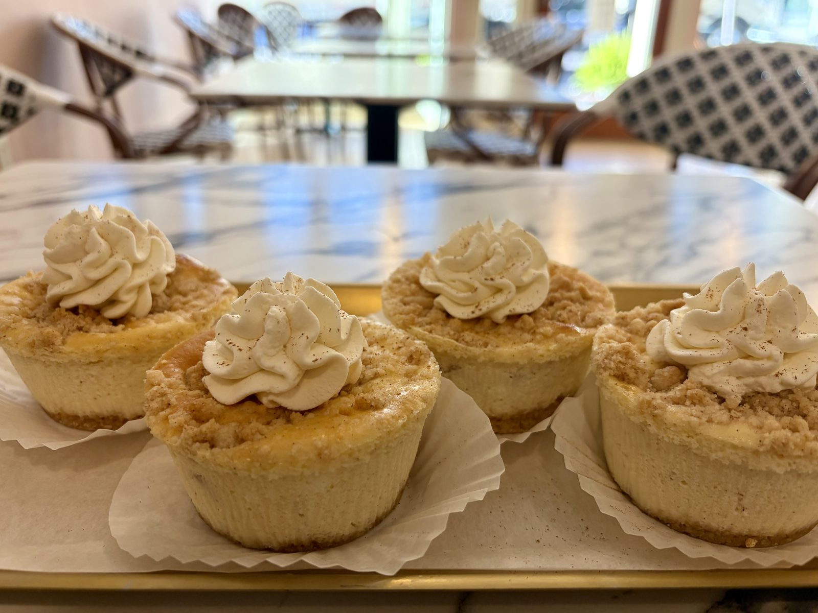 Apple crumb cheesecakes topped with whipped cream